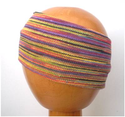 A Dreadz Fair Trade Multi-Coloured Striped Headband in Muted Bright colours on a wooden mannequin head