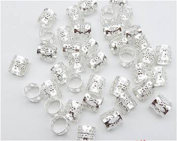 Multiple short silver 7mm hole adjustable metal tube Dreadlock Cuffs / Hair Beads displayed on grey surface