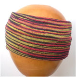 A Dreadz Fair Trade Multi-Coloured Striped Headband in Muted Rasta colours on a wooden mannequin head