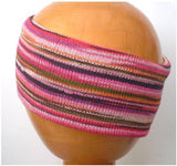 A Dreadz Fair Trade Multi-Coloured Striped Headband in Pink Rainbow colours on a wooden mannequin head