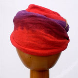 A Fair Trade Tie Dye Stretch Cotton Headwrap Dreadwrap in Purple Red colours shown on wooden mannequin head