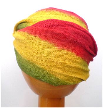 A Fair Trade Tie Dye Stretch Cotton Dreadlock Headwrap/Dreadwrap in Red, Green and Yellow colours shown on wooden mannequin head