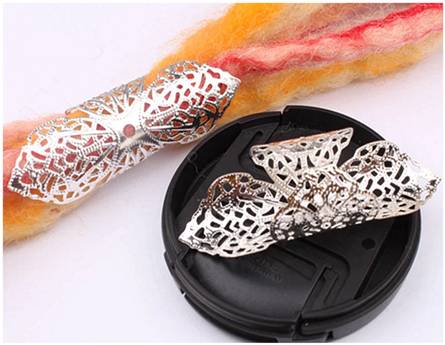 Two large silver filigree adjustable dreadlock hair cuffs with sixteen millimetre middle hole, one shown on orange red and white synthetic dreadlocks, the second shown on its own on a plastic tray