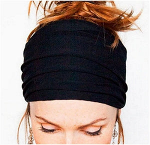 The same style lightweight, stretch, wide headband in black shown worn by a female model