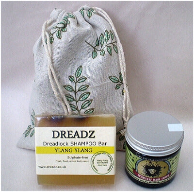 Mane Tamer Dreadlock Wax and Dreadz Ylang Ylang Dread Shampoo Bar DUO Pack Combo Kit (Style 3) shown against a sprig leaf printed drawstring bag